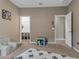 Bright playroom with a large rug, neutral walls, and easy access to the closet and the entry door at 2148 W Angelo Way, San Tan Valley, AZ 85144