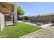 Expansive backyard with a pool, artificial turf, and a covered patio, perfect for outdoor living at 21539 N 72Nd Pl, Scottsdale, AZ 85255