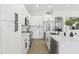 Modern kitchen featuring white cabinets, stainless steel appliances, and sleek countertops with island and bar seating at 21539 N 72Nd Pl, Scottsdale, AZ 85255