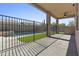 Covered patio with a wrought iron safety fence provides a view of the pool and artificial grass at 21539 N 72Nd Pl, Scottsdale, AZ 85255