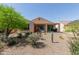 Desert backyard with a covered patio, seating, and mature xeriscaping at 27418 W Mohawk Ln, Buckeye, AZ 85396