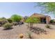 Desert backyard with a covered patio, seating, and mature xeriscaping at 27418 W Mohawk Ln, Buckeye, AZ 85396