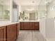 Spacious bathroom with dual sinks, vanity, large mirrors, and a glass-enclosed shower at 27418 W Mohawk Ln, Buckeye, AZ 85396