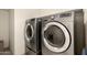 Stainless steel, front-loading washer and dryer with digital displays in laundry room at 27418 W Mohawk Ln, Buckeye, AZ 85396