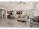 Bright, open-concept living space with modern flooring that connects to the kitchen and dining area at 27418 W Mohawk Ln, Buckeye, AZ 85396