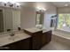 Bright bathroom with double sinks, a large mirror, and a separate soaking tub at 2955 E Hermosa Vista Dr, Mesa, AZ 85213