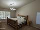 Cozy bedroom with a rustic wooden bed frame and a chandelier above at 2955 E Hermosa Vista Dr, Mesa, AZ 85213