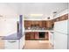 Eat-in kitchen with white appliances, ample cabinetry, and a breakfast bar at 3247 E Sheridan St, Phoenix, AZ 85008