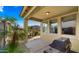 A covered back porch with outdoor dining set, BBQ and green surroundings at 3277 E Meadowview Dr, Gilbert, AZ 85298