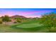 Lush golf course with manicured green, trees, and scenic mountain views at sunset in this community at 3277 E Meadowview Dr, Gilbert, AZ 85298
