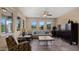 Cozy living room with three large windows with golf course views, patterned chairs and ceiling fan at 3277 E Meadowview Dr, Gilbert, AZ 85298