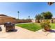 Landscaped backyard with a well-manicured lawn, a paved patio, and privacy fencing at 3536 W Cholla St, Phoenix, AZ 85029
