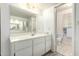 A clean bathroom with a large mirror, white cabinets, and a tiled floor at 3901 W Augusta Ave, Phoenix, AZ 85051