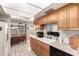 Bright galley kitchen with oak cabinets, white appliances, and view to backyard at 3901 W Augusta Ave, Phoenix, AZ 85051