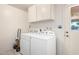 Laundry room with a washer and dryer, white cabinets, and a utility sink at 3901 W Augusta Ave, Phoenix, AZ 85051