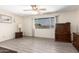 A bright living room with wood-look floors, a ceiling fan, and a large window at 3901 W Augusta Ave, Phoenix, AZ 85051