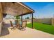 Covered patio with dining set overlooking the pool and fenced backyard with artificial turf at 3901 W Augusta Ave, Phoenix, AZ 85051