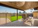 Covered patio with a dining set overlooking the fenced backyard with artificial turf at 3901 W Augusta Ave, Phoenix, AZ 85051