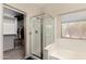Bathroom featuring glass enclosed shower, soaking tub and walk in closet at 42277 W Chisholm Dr, Maricopa, AZ 85138