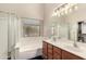 Bright bathroom featuring double sinks, soaking tub, separate shower and natural light at 42277 W Chisholm Dr, Maricopa, AZ 85138