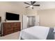 Bedroom with neutral decor, a ceiling fan, and an en suite bathroom at 42277 W Chisholm Dr, Maricopa, AZ 85138