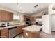 Well-lit kitchen with stainless steel appliances and tile countertops at 42277 W Chisholm Dr, Maricopa, AZ 85138