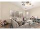 Bright living room with large windows, a comfortable couch, and a play area at 42277 W Chisholm Dr, Maricopa, AZ 85138