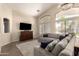 Cozy living room with plush seating, a large window, and a modern entertainment setup at 42277 W Chisholm Dr, Maricopa, AZ 85138