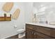 Bright bathroom with a white countertop, wooden vanity and decorative wall hangings at 46422 W Lander Ln, Maricopa, AZ 85139