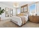 A well-lit bedroom with an elegant chandelier and warm wood tones with decor at 46422 W Lander Ln, Maricopa, AZ 85139
