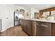 Kitchen showcasing stainless steel appliances, wood cabinets, and a spacious island with a sink at 46422 W Lander Ln, Maricopa, AZ 85139