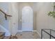 Bright foyer featuring tile flooring, a staircase with wood railing, and an arched front door at 4700 S Fulton Ranch Blvd # 62, Chandler, AZ 85248