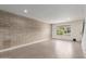 Bright living room featuring a brick wall, large window, and tile flooring at 4701 N 68Th St # 214, Scottsdale, AZ 85251