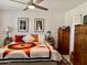 Bright bedroom with brick wall has a colorful quilt, ceiling fan and charming decor at 4800 N 68Th St # 164, Scottsdale, AZ 85251