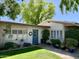 Charming single-story home featuring a blue front door, lush landscaping, and well-maintained lawn at 4800 N 68Th St # 164, Scottsdale, AZ 85251