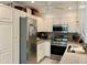 Well-lit kitchen features stainless steel appliances, white cabinetry, and a ceiling fan for added comfort at 4800 N 68Th St # 164, Scottsdale, AZ 85251