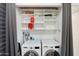 Bright laundry room featuring a stacked washer and dryer and built-in storage shelves at 4800 N 68Th St # 207, Scottsdale, AZ 85251