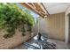 Cozy brick patio with table and chairs, an awning, and mature shrubs at 4800 N 68Th St # 207, Scottsdale, AZ 85251
