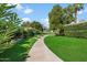 Beautifully landscaped yard with mature trees and a walkway at 4800 N 68Th St # 207, Scottsdale, AZ 85251