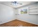 Bedroom features hardwood floors, a ceiling fan, white walls, and a window with built in shelving at 500 E Hermosa Dr, Tempe, AZ 85282