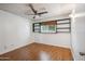 Bedroom features hardwood floors, a ceiling fan, white walls, and a window with shelves above at 500 E Hermosa Dr, Tempe, AZ 85282
