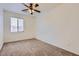 Carpeted bedroom with a ceiling fan and a window providing natural light at 6815 W Carter Rd, Laveen, AZ 85339