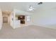 Open-concept living room featuring an arched doorway to kitchen with modern ceiling fan and neutral-toned carpet at 6815 W Carter Rd, Laveen, AZ 85339