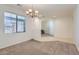 Comfortable living room featuring plush carpeting, a modern light fixture, and neutral paint at 6815 W Carter Rd, Laveen, AZ 85339