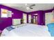 Spacious bedroom featuring vibrant purple walls and offering a glimpse into an adjoining room at 7039 W Katharine Way, Peoria, AZ 85383