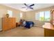 Comfortable bedroom featuring a blue ceiling fan, a single bed, and a wooden dresser with natural light from a window at 7039 W Katharine Way, Peoria, AZ 85383
