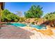 Inviting pool with waterfall feature, lush landscaping, and spacious deck for relaxing and enjoying the outdoors at 7039 W Katharine Way, Peoria, AZ 85383
