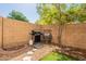 Private backyard featuring a built-in gas grill, mature trees, and landscaping at 7227 E Kramer St, Mesa, AZ 85207
