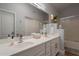 Bathroom with dual vanity sinks, a large mirror, and a combined shower and bathtub at 7227 E Kramer St, Mesa, AZ 85207