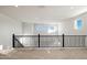 Bright bonus room featuring neutral carpet and walls, with iron railing and ample natural light from multiple windows at 7385 W Buckhorn Trl, Peoria, AZ 85383